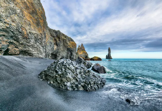 Basalt rocks and sea stacks on a black sand beach near Vík, Iceland
